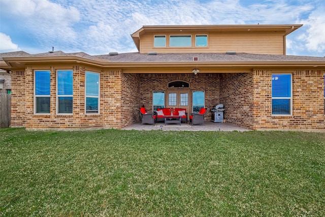 back of property with brick siding, a patio area, an outdoor living space, and a yard