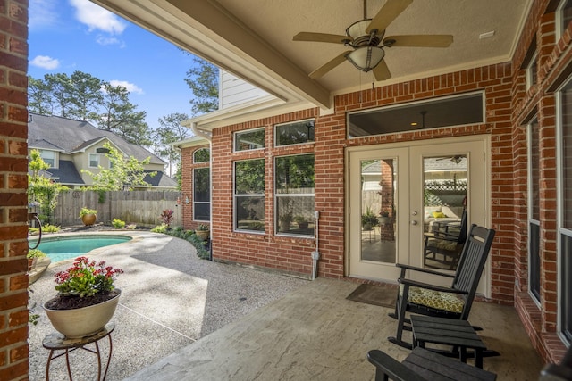view of patio / terrace with fence, a fenced in pool, ceiling fan, and french doors