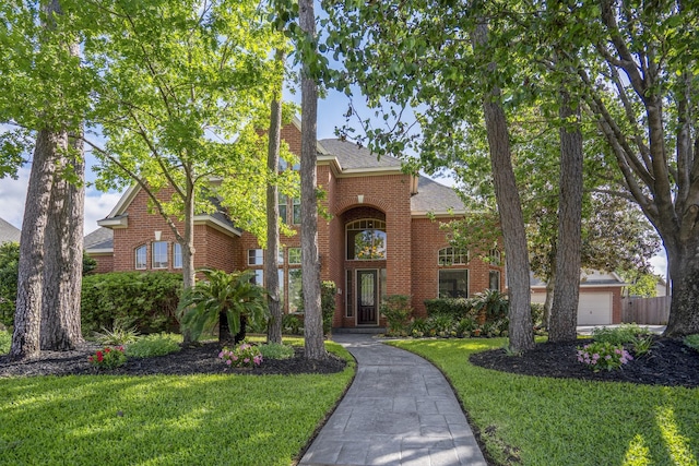 traditional-style home featuring brick siding, a shingled roof, and a front lawn