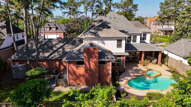 back of house featuring a patio area, a fenced backyard, brick siding, and a residential view