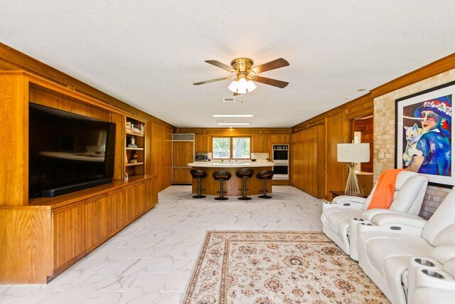 1717 S Columbia Dr, West Columbia, TX 77486 - living area featuring ceiling fan, wood walls, and light marble finish floors