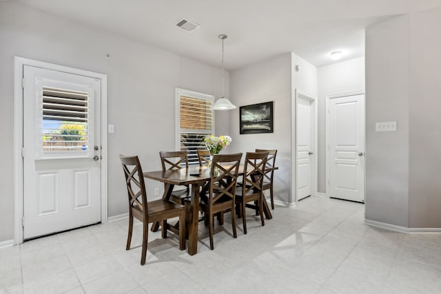 dining room featuring baseboards, visible vents, and light tile patterned flooring