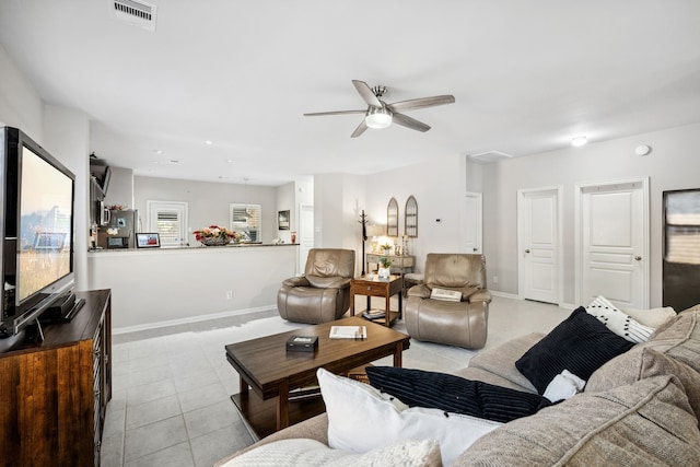 living room with baseboards, a ceiling fan, visible vents, and light tile patterned floors