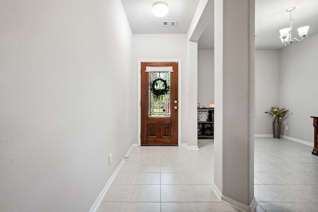 entryway with baseboards, visible vents, a chandelier, and light tile patterned flooring