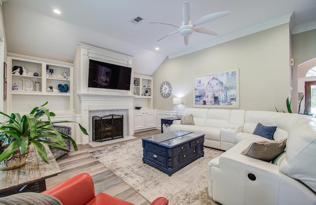 living area with light wood-style floors, ornamental molding, a ceiling fan, visible vents, and a high end fireplace