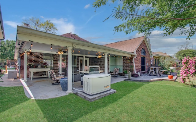 rear view of house featuring a shingled roof, a yard, a patio area, a ceiling fan, and brick siding