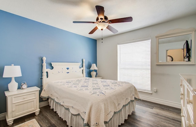 bedroom featuring a ceiling fan, baseboards, and dark wood-style flooring