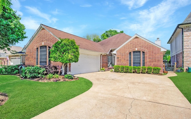 ranch-style house featuring concrete driveway, fence, brick siding, a garage, and a front yard