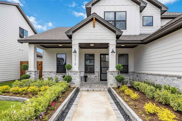 3314 Arbor, Houston, TX 77004 - view of exterior entry with board and batten siding, a porch, roof with shingles, and brick siding