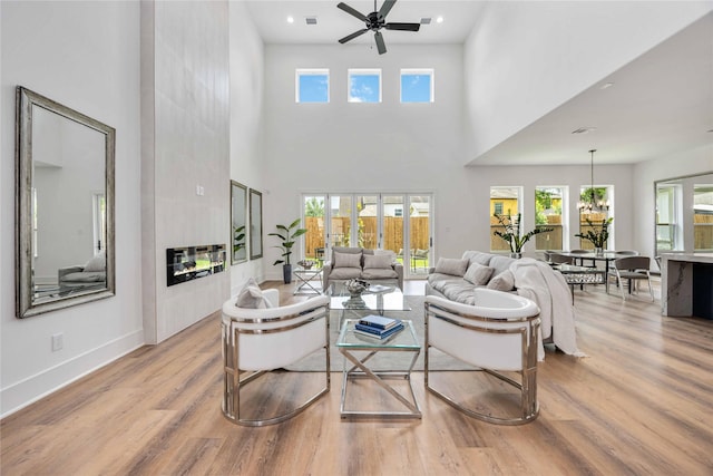 3314 Arbor, Houston, TX 77004 - living area featuring wood finished floors, a high ceiling, a ceiling fan, baseboards, and a fireplace