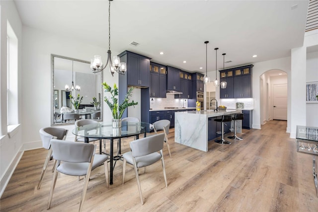 3314 Arbor, Houston, TX 77004 - dining room with a chandelier, arched walkways, light wood-style floors, recessed lighting, and baseboards