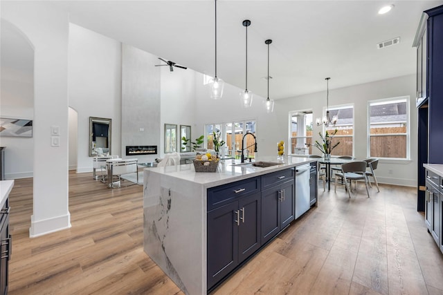 3314 Arbor, Houston, TX 77004 - kitchen featuring a sink, arched walkways, light wood-style floors, baseboards, and stainless steel dishwasher