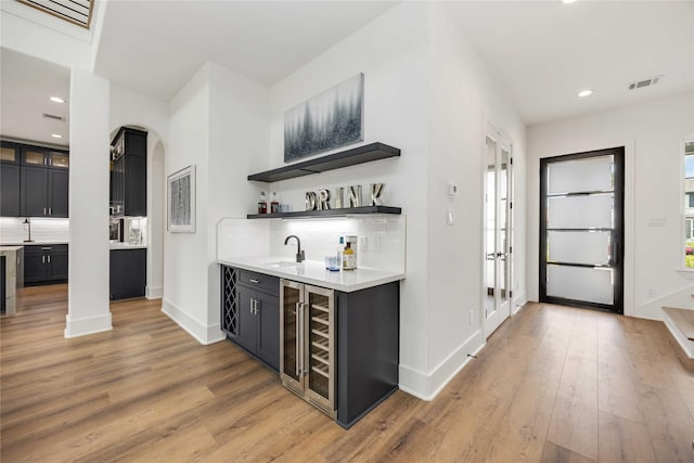 3314 Arbor, Houston, TX 77004 - indoor wet bar with wine cooler, light wood-type flooring, recessed lighting, arched walkways, and backsplash