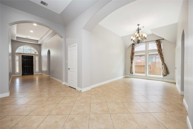 2423 Rosillos Peak Dr, Spring, TX 77386 - foyer with arched walkways, a chandelier, light tile patterned flooring, a raised ceiling, and lofted ceiling