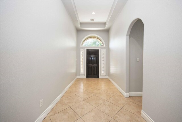 2423 Rosillos Peak Dr, Spring, TX 77386 - foyer entrance featuring arched walkways, light tile patterned floors, a raised ceiling, and baseboards