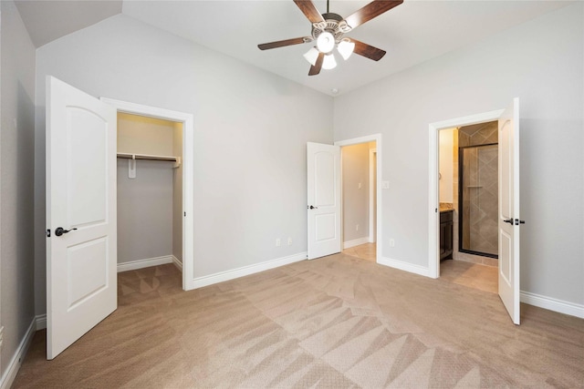 2423 Rosillos Peak Dr, Spring, TX 77386 - unfurnished bedroom featuring light carpet, a spacious closet, ensuite bathroom, baseboards, and lofted ceiling