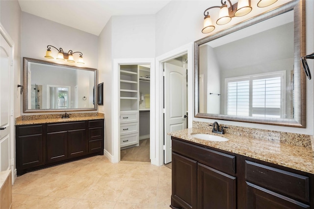 2423 Rosillos Peak Dr, Spring, TX 77386 - bathroom featuring two vanities, plenty of natural light, a spacious closet, and tile patterned floors