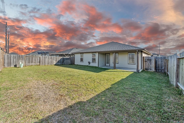 29607 Ella Larchmont Ct, Katy, TX 77494 - back of property at dusk featuring a shingled roof, a fenced backyard, and a lawn