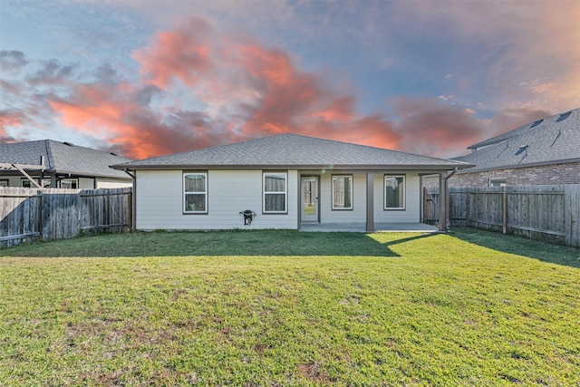 29607 Ella Larchmont Ct, Katy, TX 77494 - back of property at dusk featuring a yard, a fenced backyard, and a shingled roof