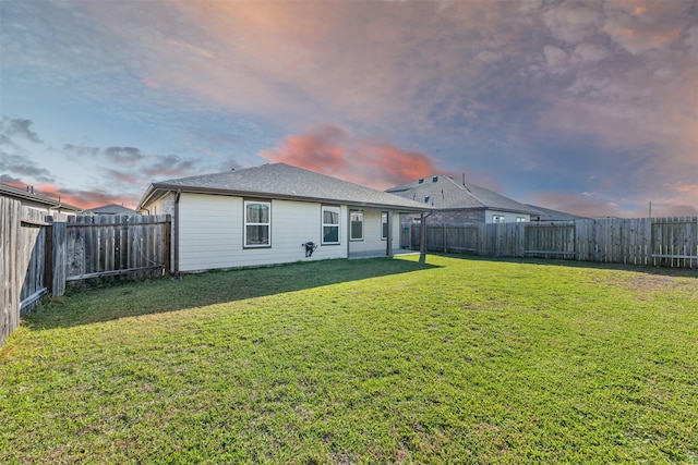 29607 Ella Larchmont Ct, Katy, TX 77494 - back of house at dusk featuring a fenced backyard, a shingled roof, and a lawn