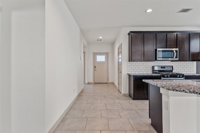 29607 Ella Larchmont Ct, Katy, TX 77494 - kitchen featuring baseboards, dark brown cabinetry, stainless steel appliances, stone counters, and backsplash
