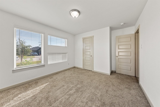 29607 Ella Larchmont Ct, Katy, TX 77494 - unfurnished bedroom with a closet, baseboards, and light carpet