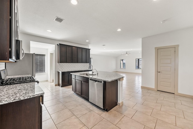 29607 Ella Larchmont Ct, Katy, TX 77494 - kitchen featuring dark brown cabinetry, backsplash, visible vents, appliances with stainless steel finishes, and a sink