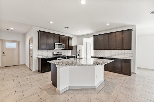 29607 Ella Larchmont Ct, Katy, TX 77494 - kitchen with tasteful backsplash, dark brown cabinetry, light stone countertops, visible vents, and stainless steel appliances