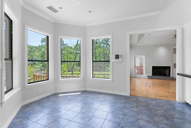 unfurnished living room featuring ornamental molding, visible vents, and a wealth of natural light