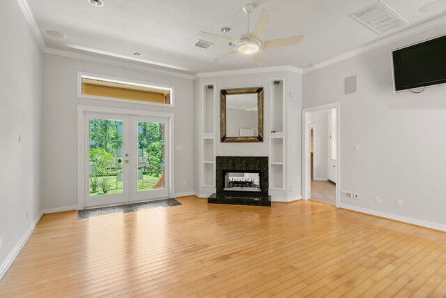 unfurnished living room with ceiling fan, ornamental molding, and visible vents