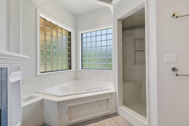 bathroom with a bath, a healthy amount of sunlight, tile patterned flooring, and walk in shower