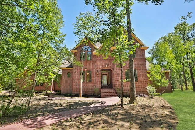 traditional home with brick siding and a front lawn