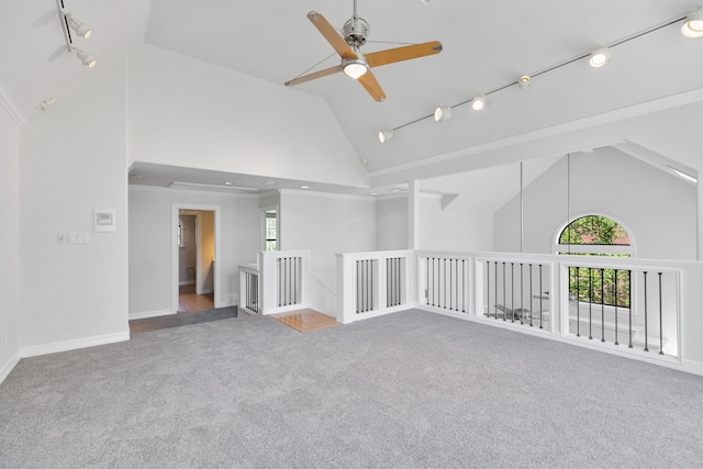 spare room with a ceiling fan, high vaulted ceiling, carpet flooring, and a healthy amount of sunlight