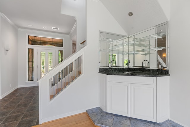 bar featuring crown molding, wet bar, visible vents, stairs, and baseboards