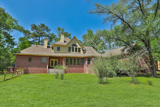 rear view of property with fence, crawl space, a chimney, and a lawn