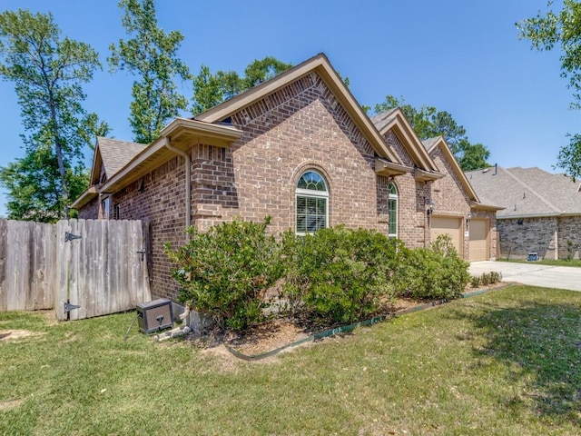 view of front of property with brick siding, a front yard, a garage, and concrete driveway