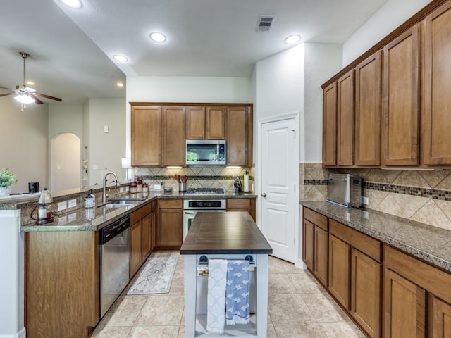 kitchen with a sink, visible vents, brown cabinetry, and stainless steel appliances