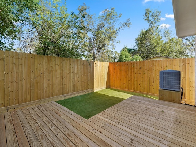 wooden deck featuring a fenced backyard, a lawn, and central air condition unit