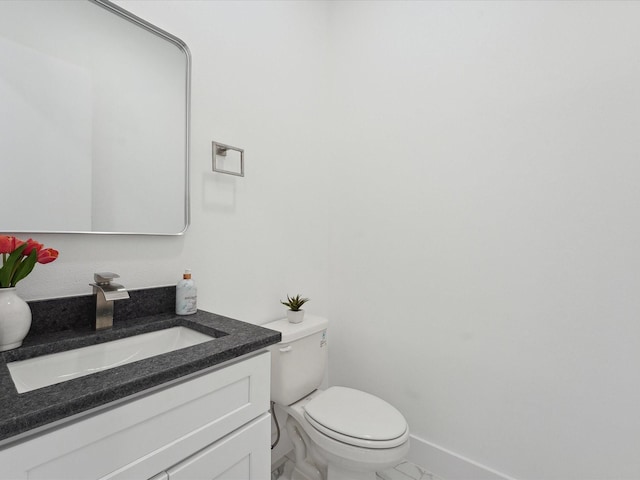 bathroom featuring vanity, baseboards, and toilet