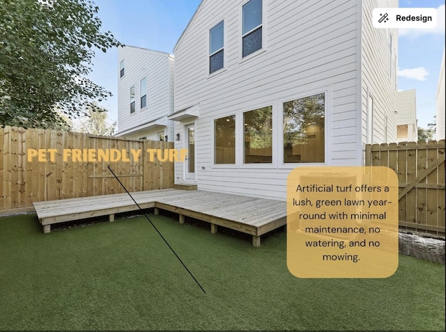 rear view of house with a wooden deck and fence