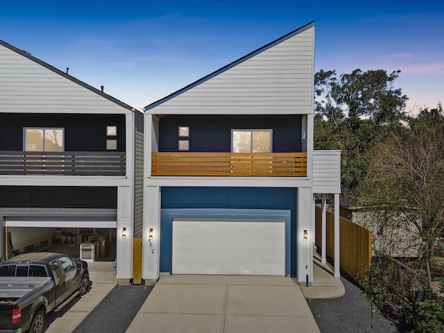 view of front of house featuring a garage, driveway, and a balcony