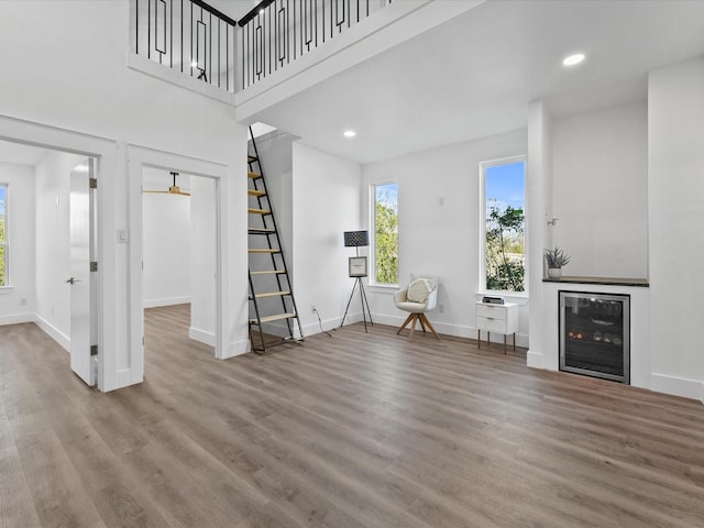 living area featuring wood finished floors, recessed lighting, baseboards, and stairs