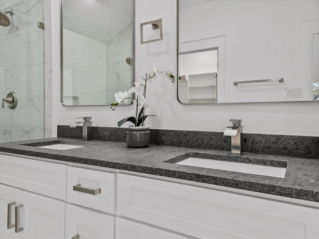 full bathroom with a marble finish shower and a sink
