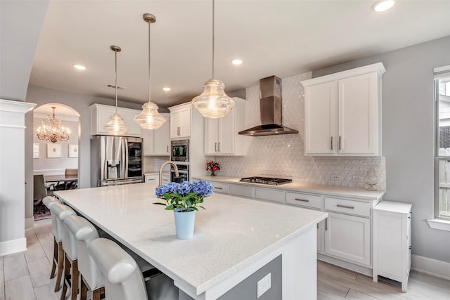 404 Christians Ct, Montgomery, TX 77316 - kitchen featuring a notable chandelier, tasteful backsplash, wall chimney range hood, and stainless steel appliances