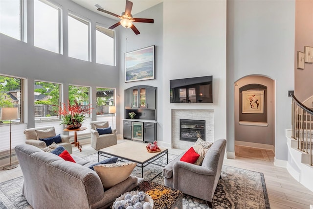 404 Christians Ct, Montgomery, TX 77316 - living room with stairway, a glass covered fireplace, a high ceiling, and ceiling fan