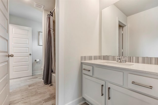404 Christians Ct, Montgomery, TX 77316 - bathroom with baseboards, visible vents, vanity, and shower / bath combo with shower curtain