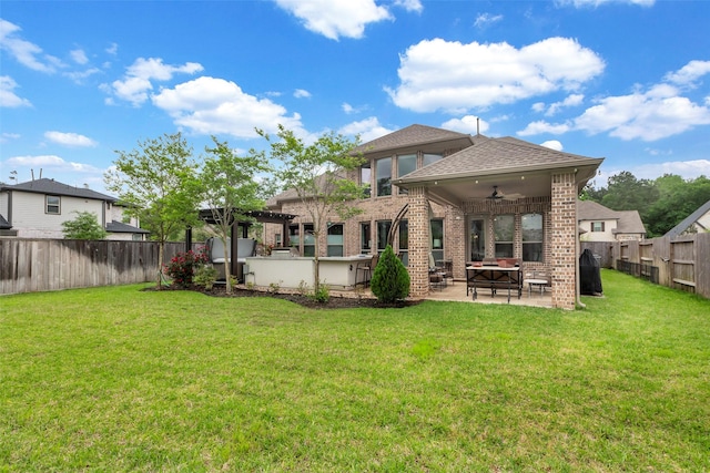 404 Christians Ct, Montgomery, TX 77316 - back of house with a fenced backyard, brick siding, a lawn, ceiling fan, and a patio