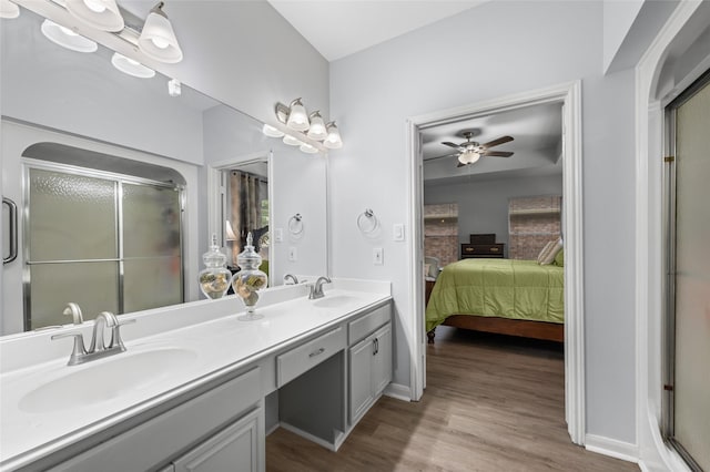 ensuite bathroom with a shower stall, ensuite bathroom, a sink, and wood finished floors