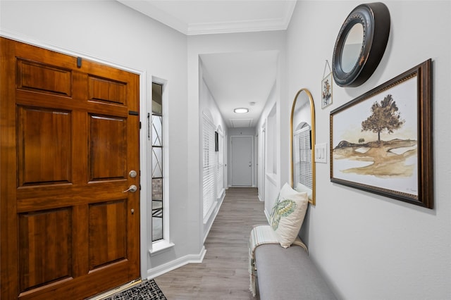 foyer with wood finished floors, baseboards, and ornamental molding