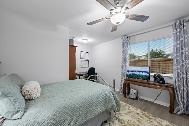 bedroom featuring baseboards, a ceiling fan, and wood finished floors